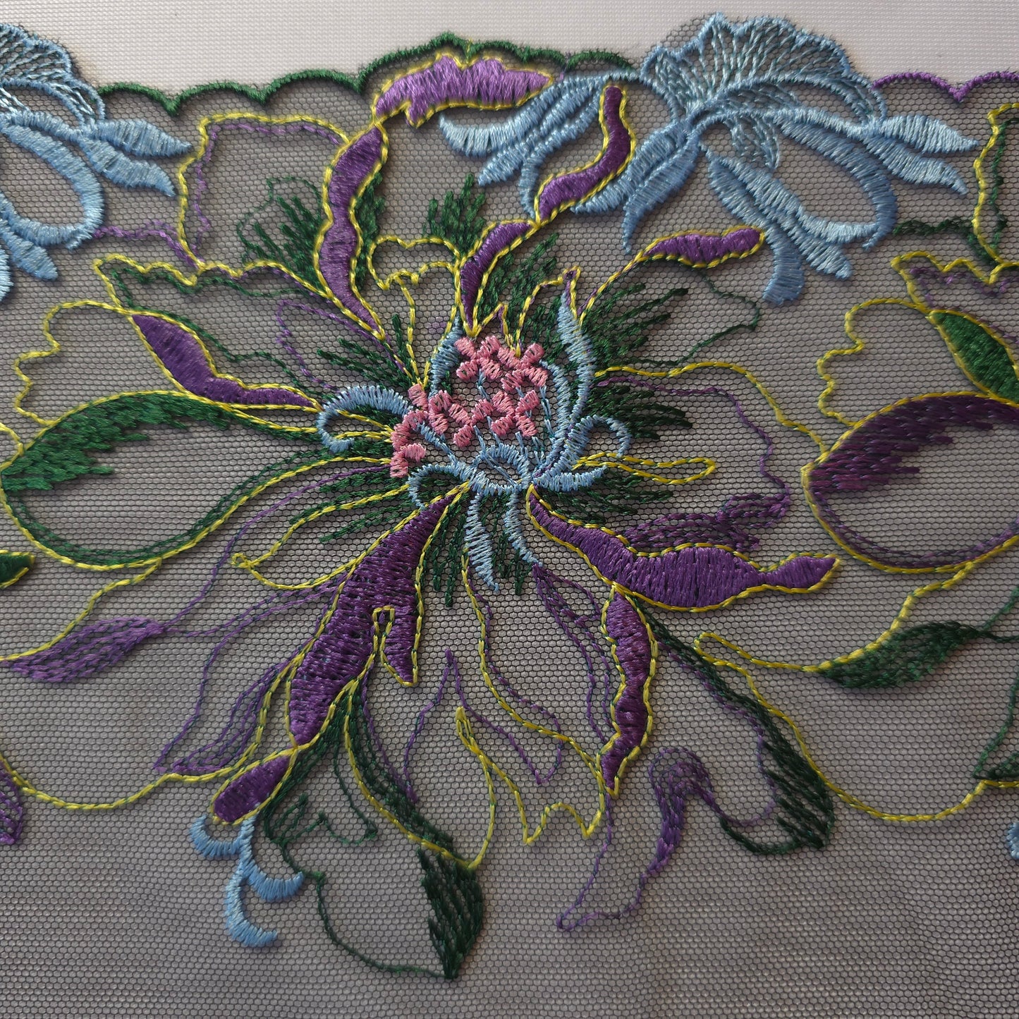 2025-120 zwart tule kant met grote geborduurde bloemen in lichtblauw, paars, lila-roze, groen en chartreuse