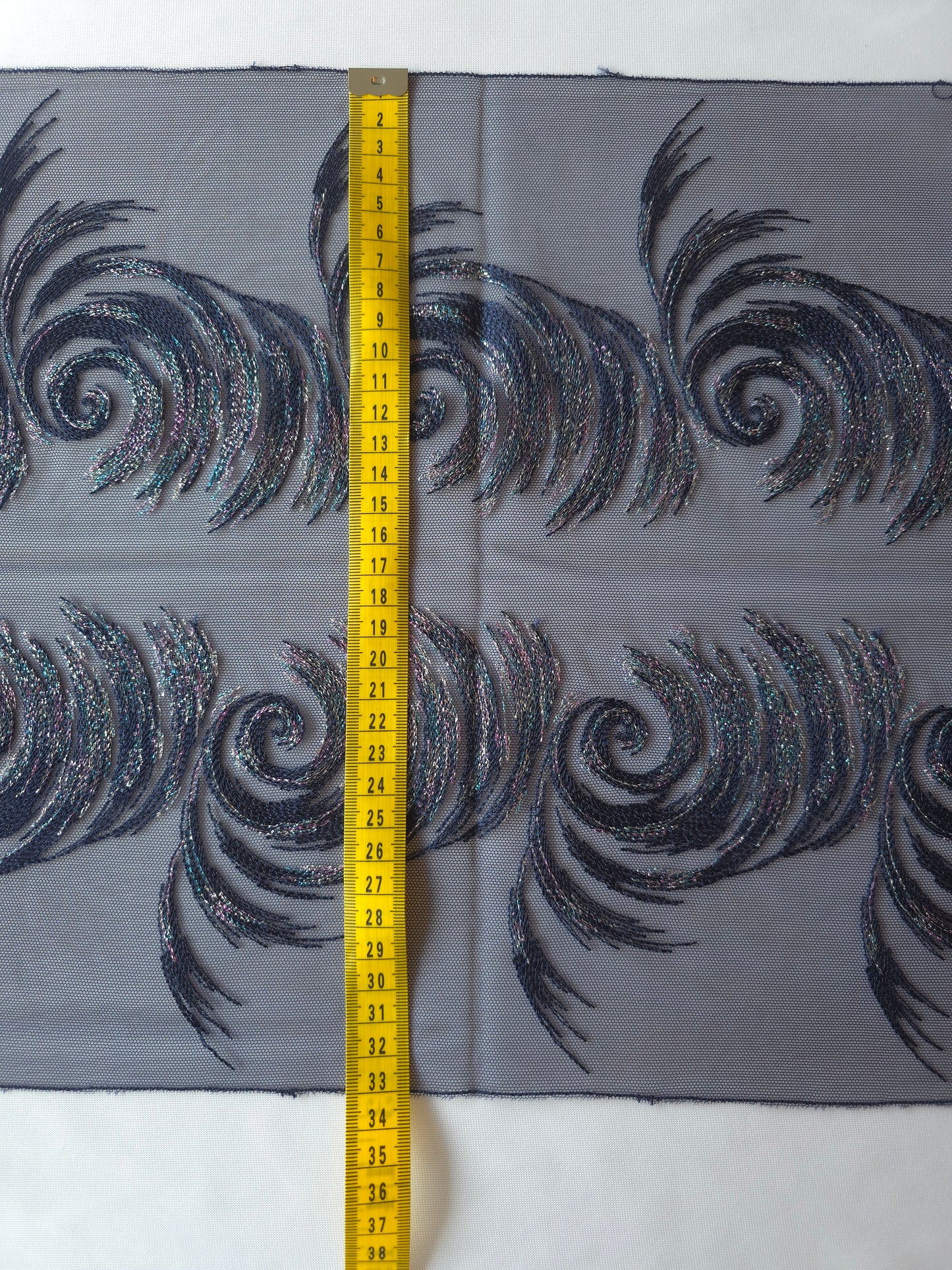 2025-123 donker blauw tule kant met abstracte golven voorzien van veelkleurig lurexdraad