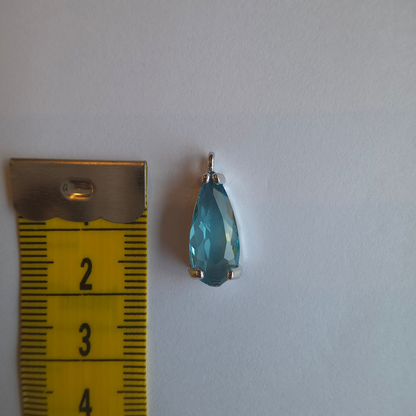 zilverkleurig bedeltje met druppelvormige zirkoon in lichtblauw