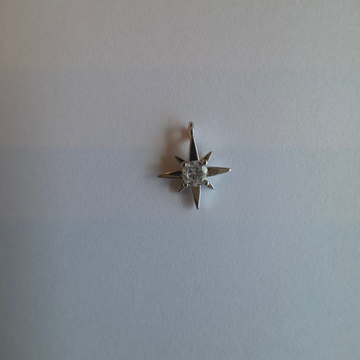 zilverkleurig bedeltje van sterretje met zirkoontje