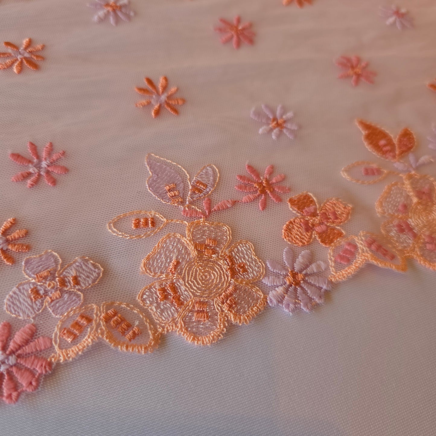 2026-13 lichtroze geborduurd stretchkant met bloemetjes in roze, peach, licht oranje en lila