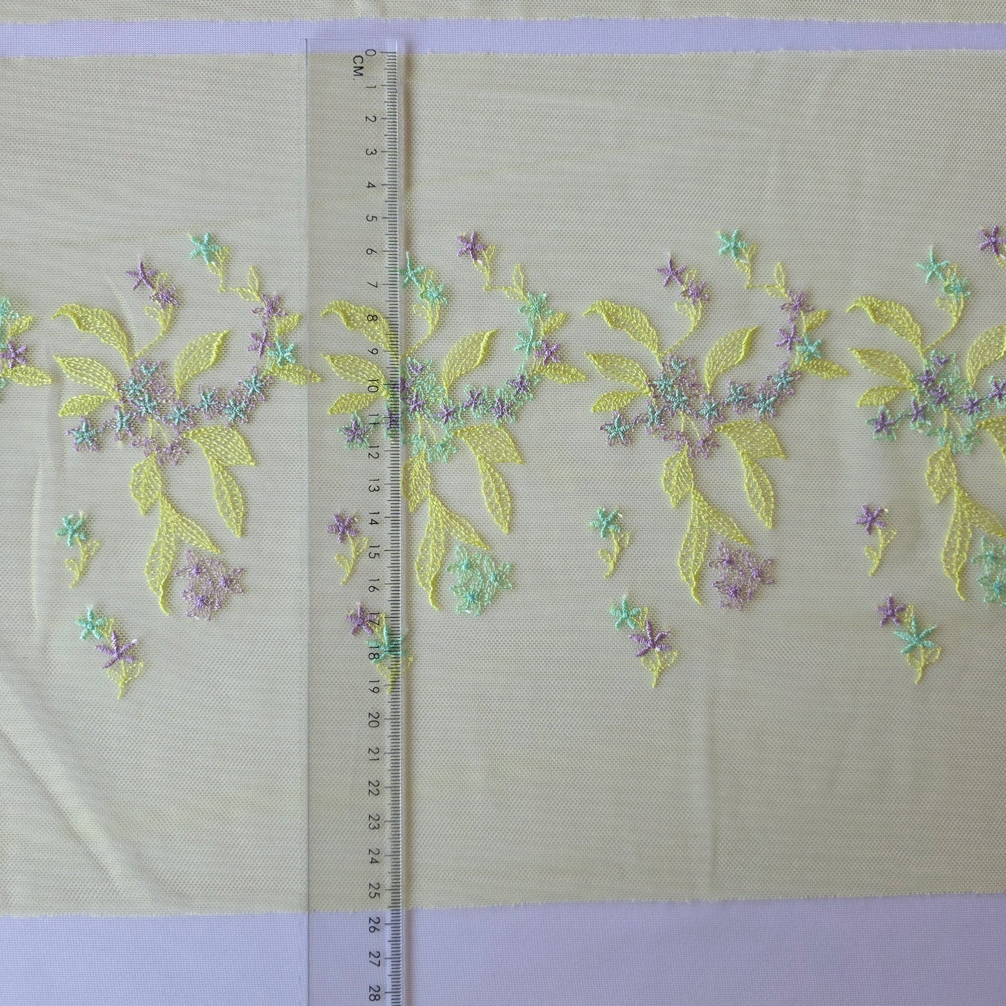 2026-32 licht chartreuse tule kant met in chartreuse, lichtblauw en lila geborduurde bloemetjes