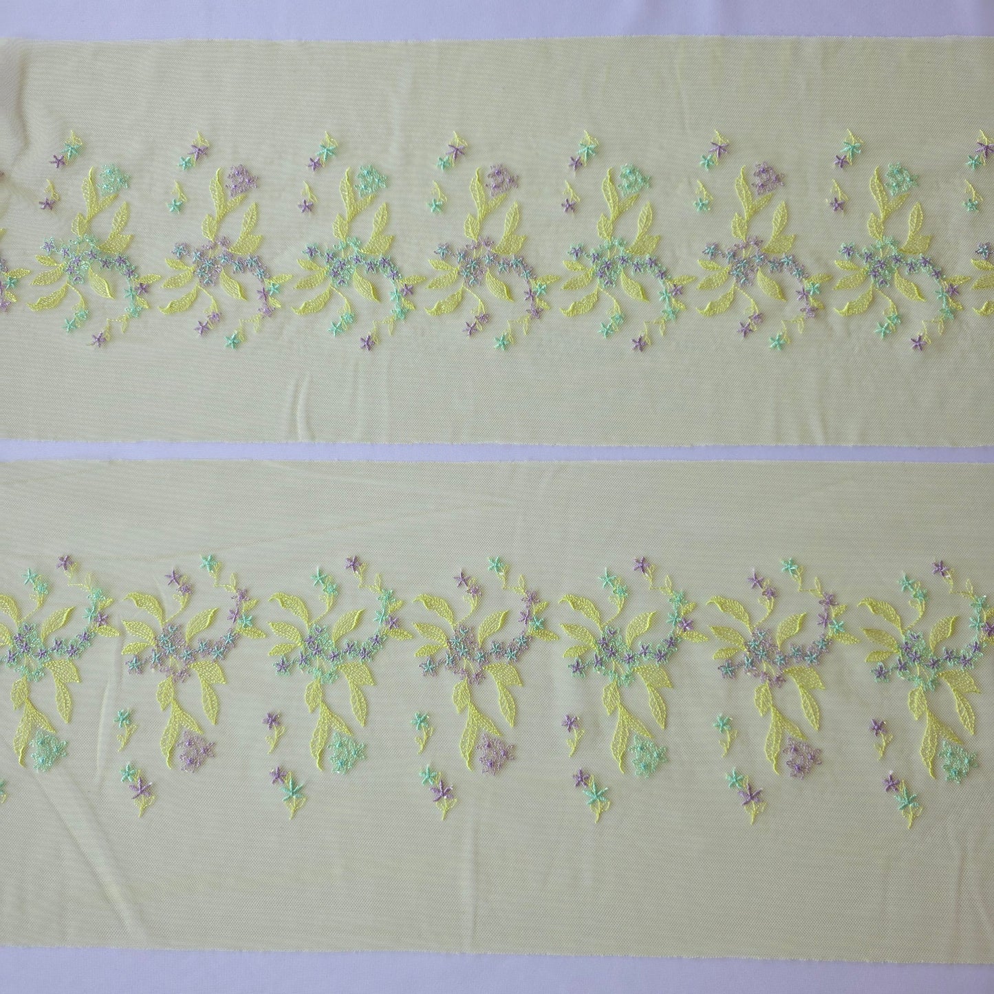 2026-32 licht chartreuse tule kant met in chartreuse, lichtblauw en lila geborduurde bloemetjes
