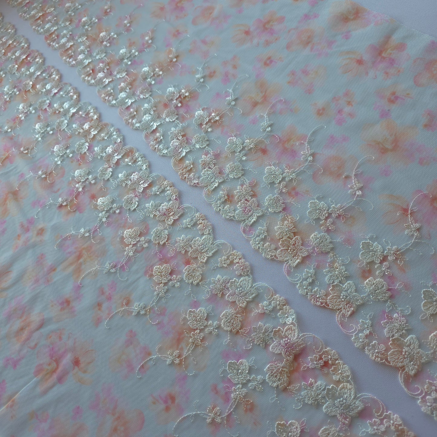 2026-57 tulekant met print in pastel kleuren voorzien van wit borduursel met zilverkleurige lurex draad