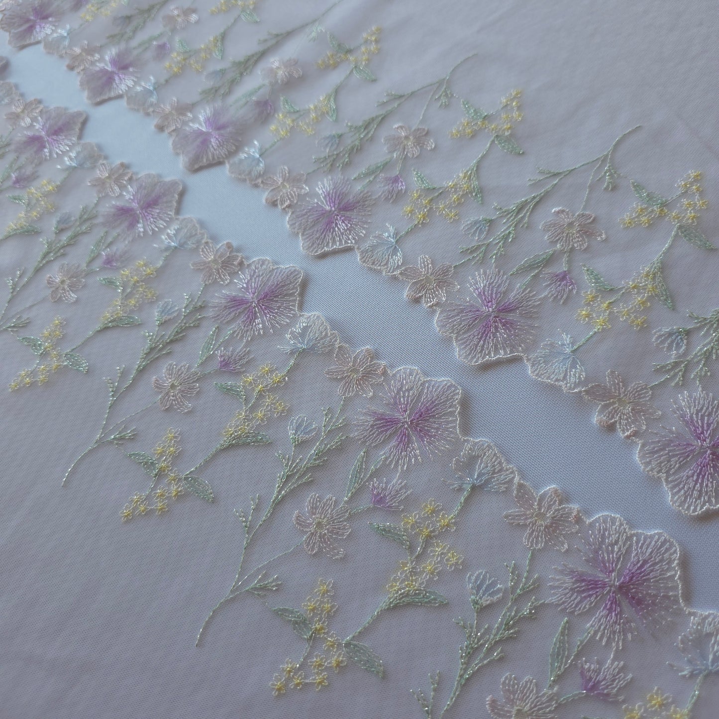 2026-58 licht roze-lila tule kant met geborduurde veldbloemen voorzien van zilverkleurig lurexdraadje
