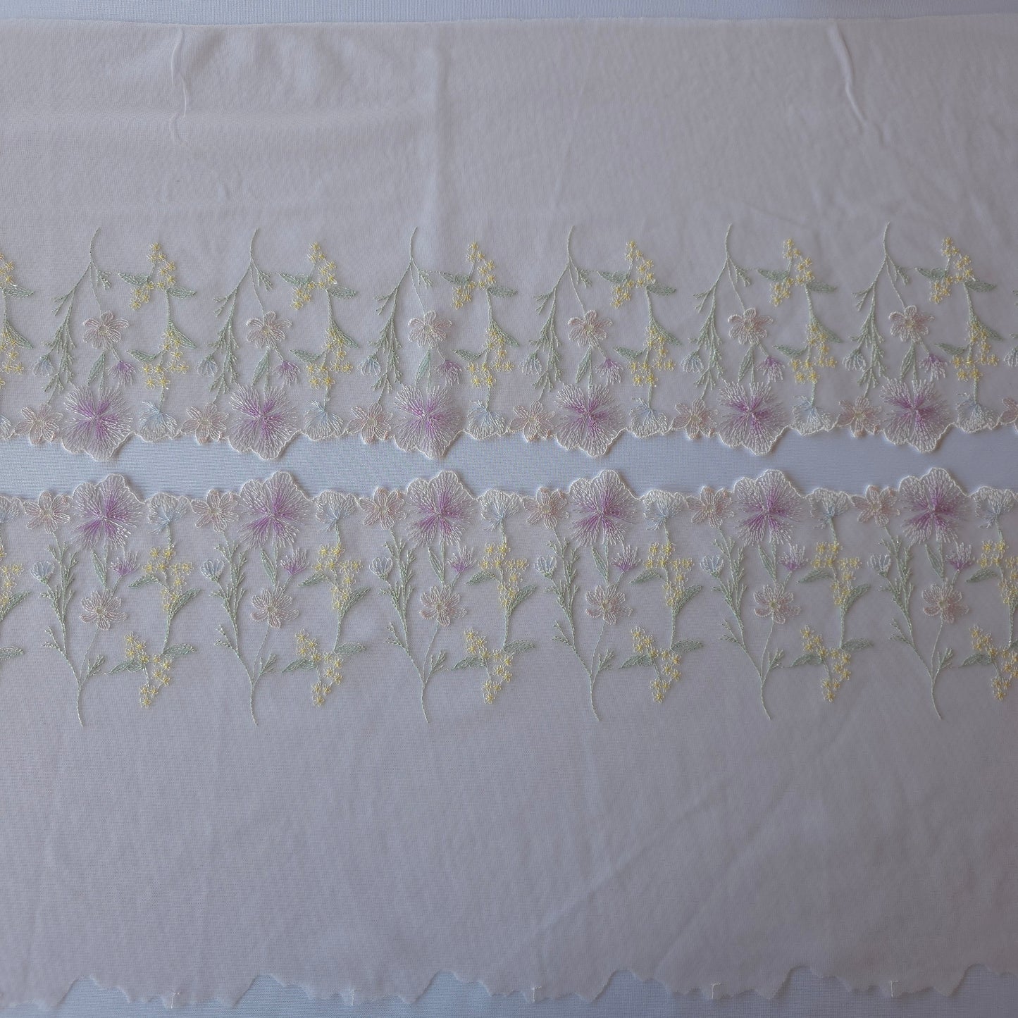 2026-58 licht roze-lila tule kant met geborduurde veldbloemen voorzien van zilverkleurig lurexdraadje