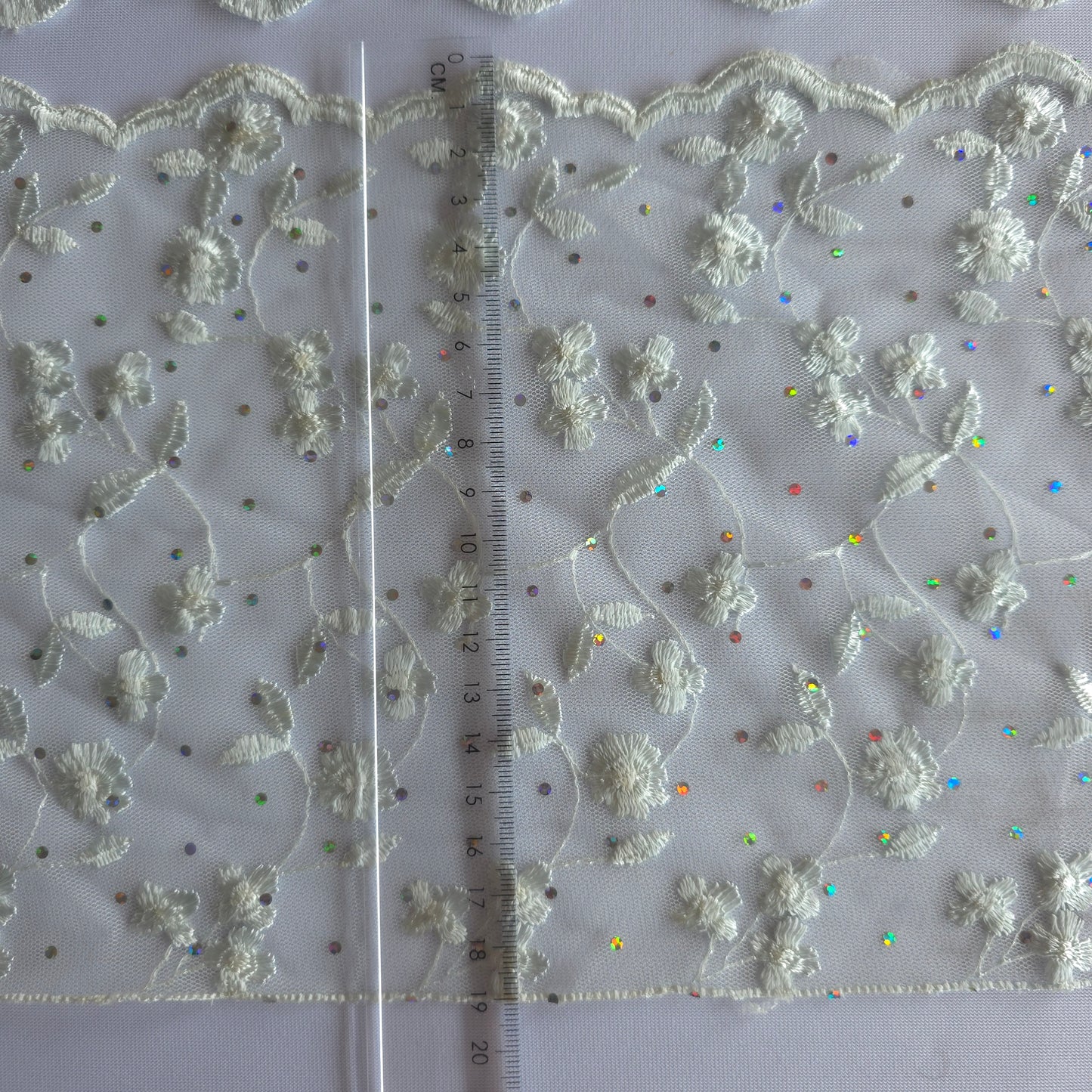 2026-73 zilvergrijs tule kant met iriserende polkadotjes van folie