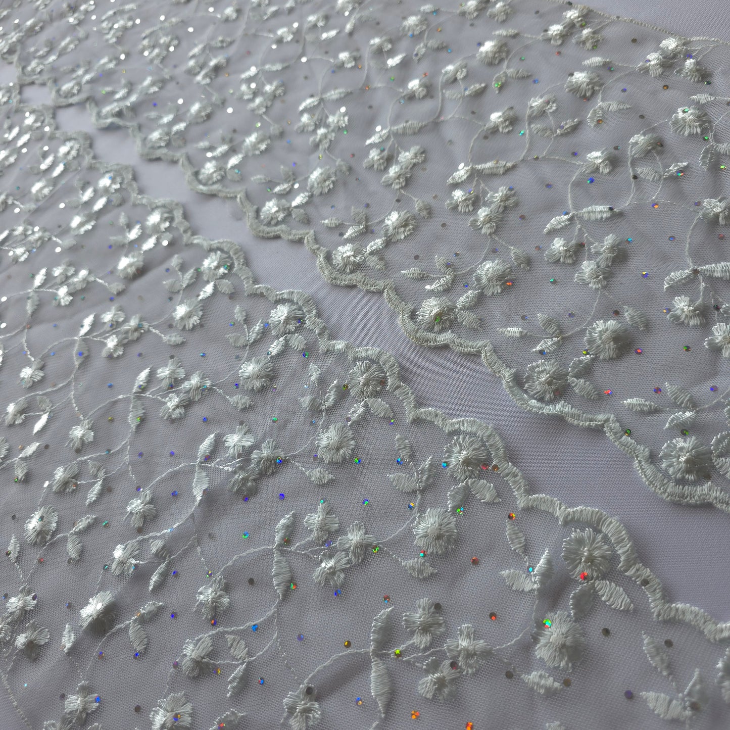 2026-73 zilvergrijs tule kant met iriserende polkadotjes van folie