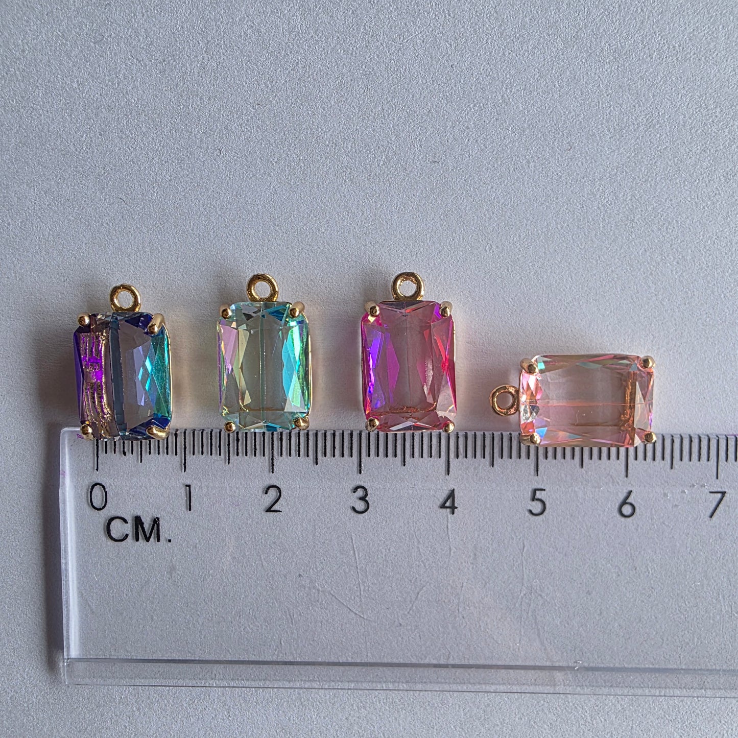 met 18k vergulde bedeltjes met rechthoekige, iriserende zirconia in verschillende kleuren