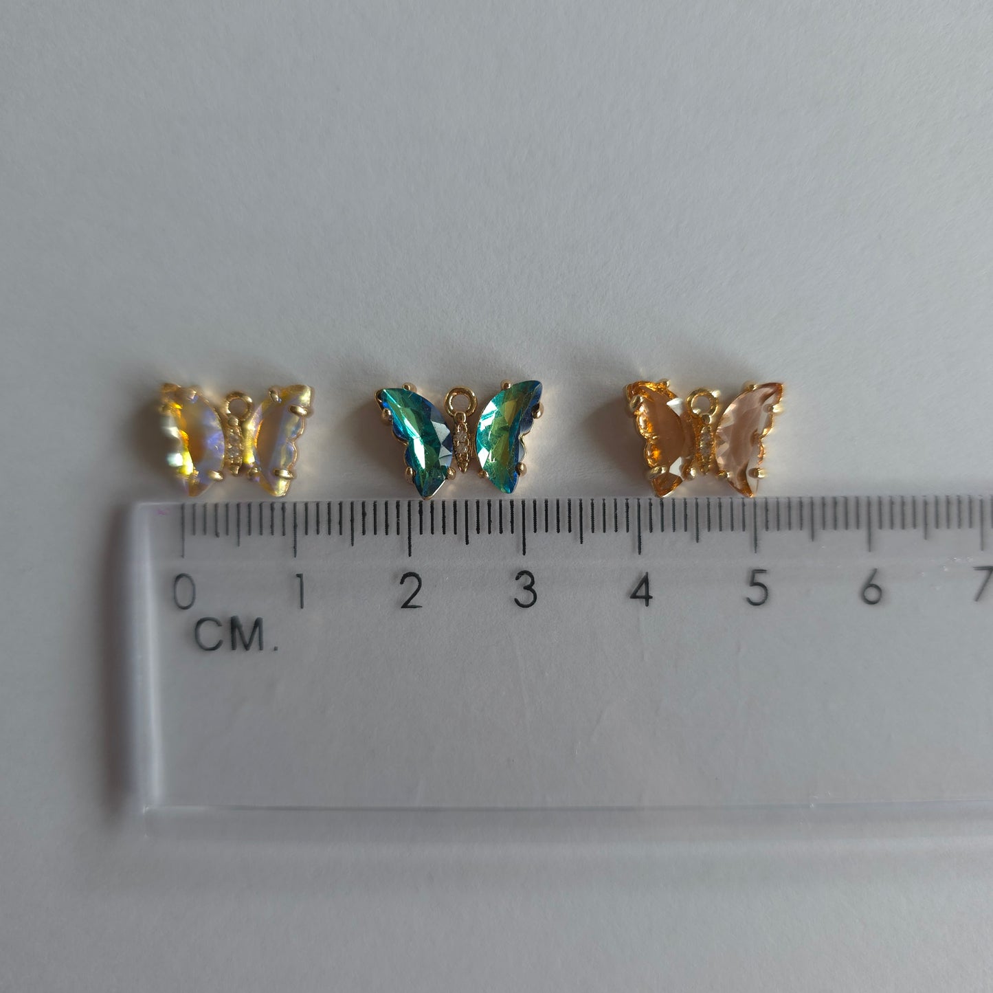 Goudkleurige vlinder-bedeltjes met lichtroze zirconia + ingelegde zirconiatjes in het lijfje in verschillende kleuren
