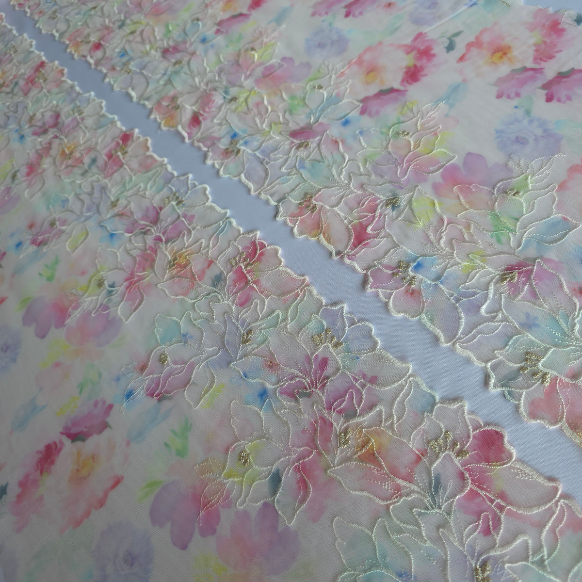 2026-85 roomwit stretchmesh kant met kleurrijke bloemenprint en geborduurde bloemen voorzien van goudkleurig lurexdraadzien