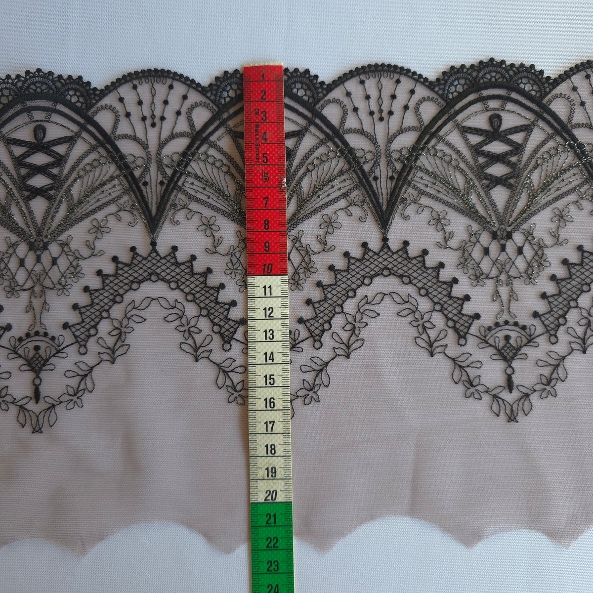2026-99 taupe kleurig tulekant met guipurerandje voorzien van sprookjesachtig borduursel in zwart en zilverkleurig lurex draad