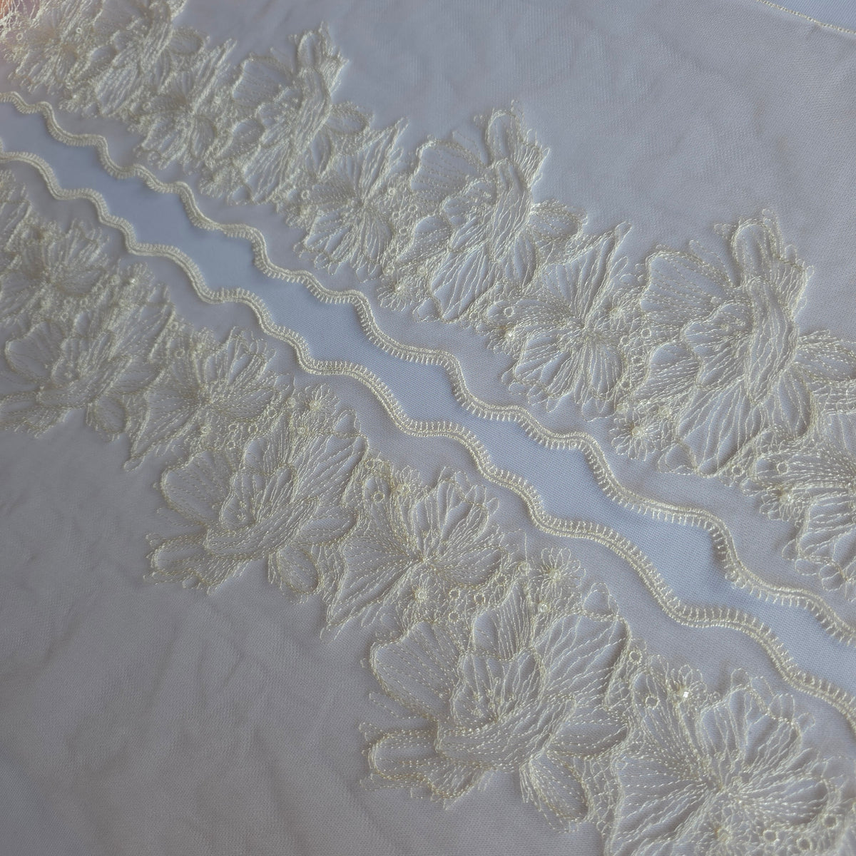 2026-100 beige tule kant met geborduurde bloemen in witte lineart voorzien van glaskraaltjes