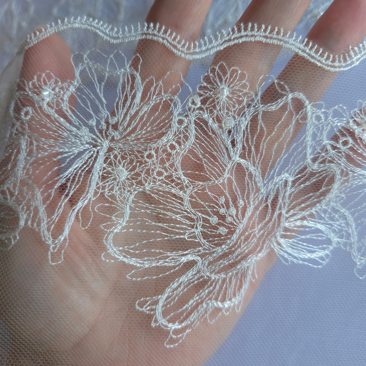 2026-100 beige tule kant met geborduurde bloemen in witte lineart voorzien van glaskraaltjes