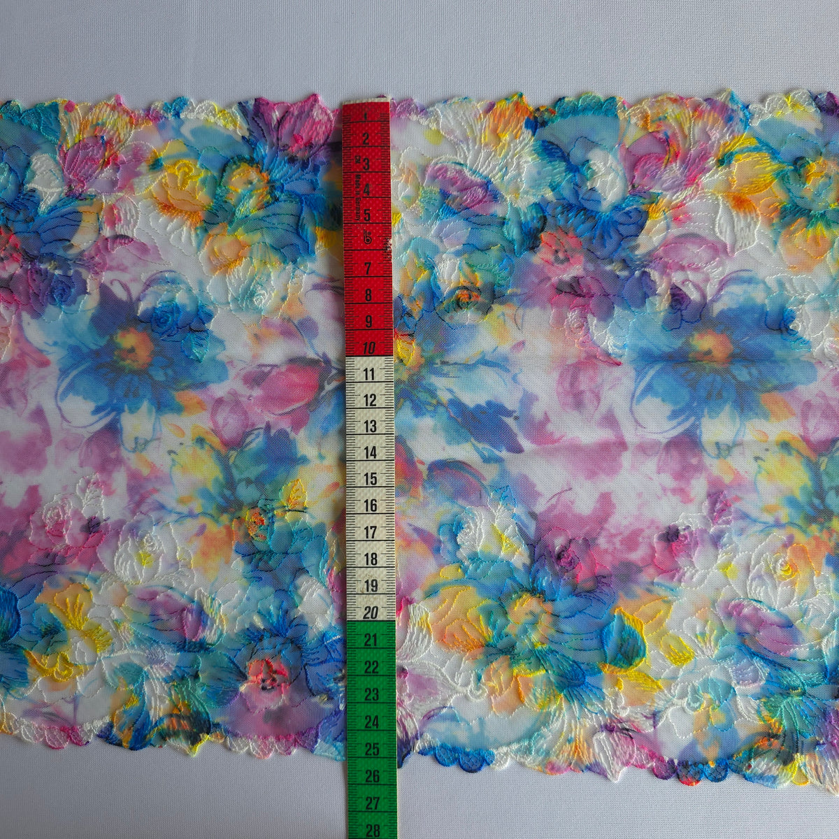 2026-106 wit tule kant met bloemen borduursel voorzien van print in blauw, fuchsia, paars en geel