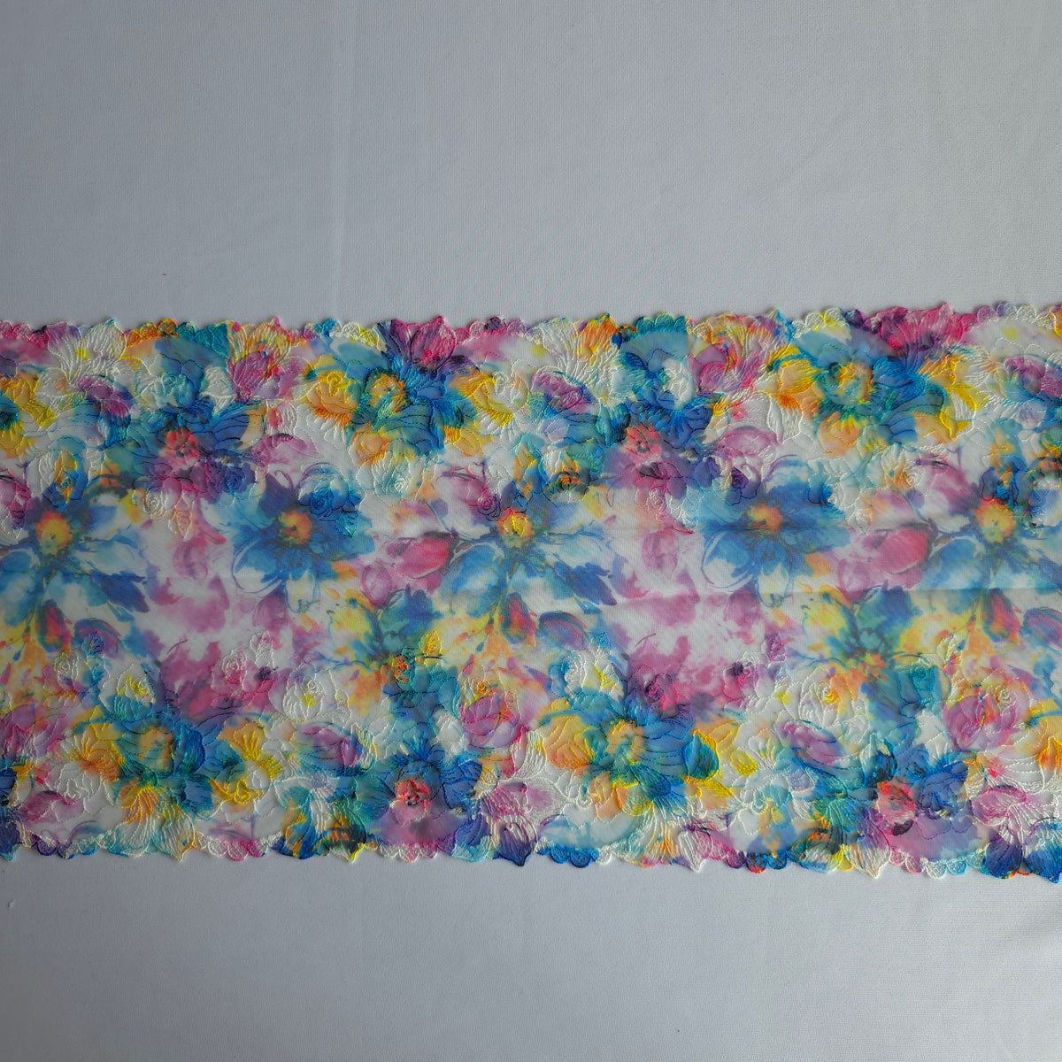 2026-106 wit tule kant met bloemen borduursel voorzien van print in blauw, fuchsia, paars en geel