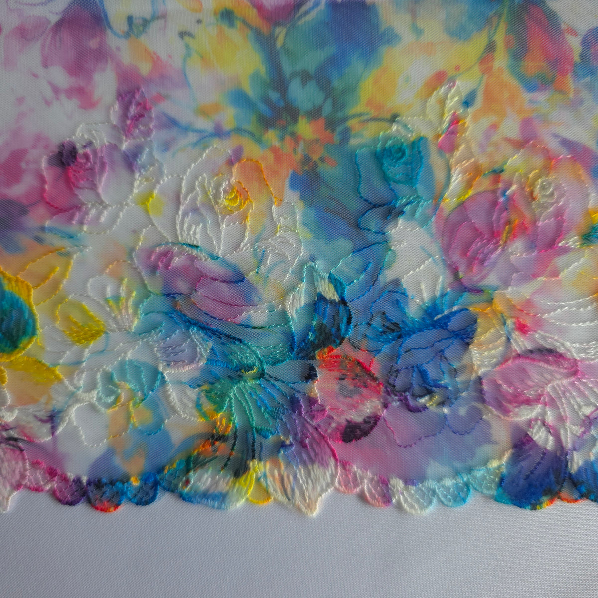 2026-106 wit tule kant met bloemen borduursel voorzien van print in blauw, fuchsia, paars en geel