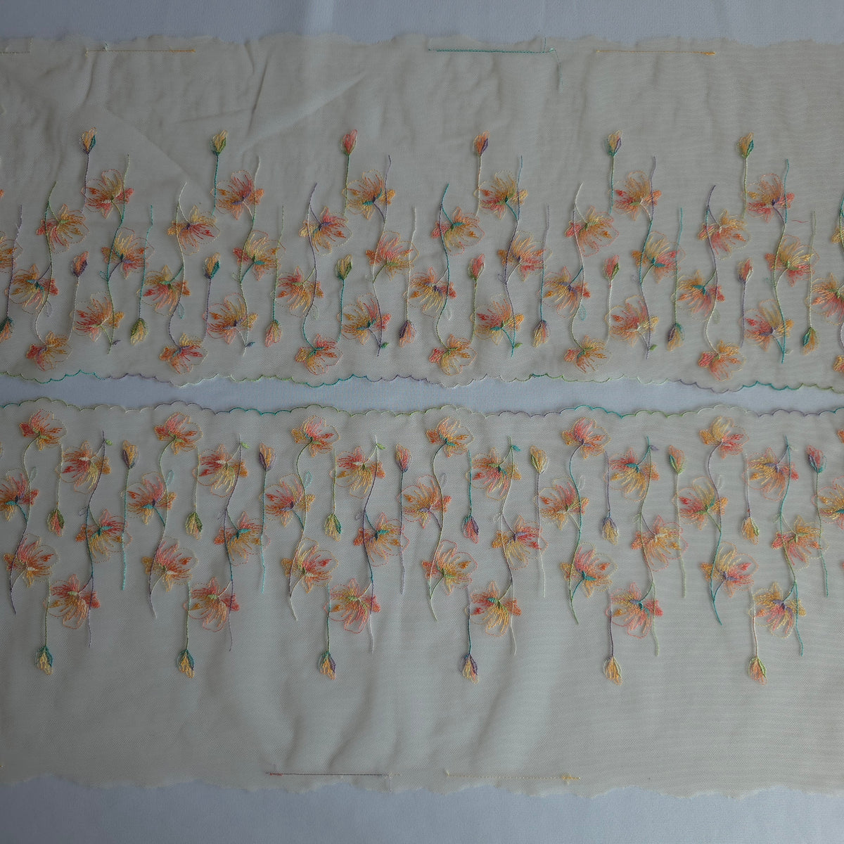 2026-107 prachtig peacht kleurig tulekant met geborduurde klaproosjes in kleurrijke pasteltinten