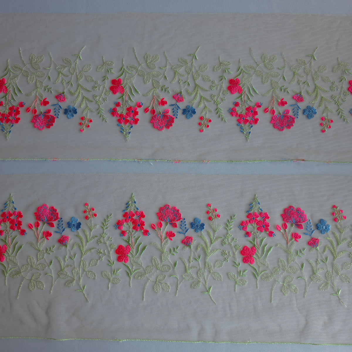 2026-112 peach kleurig tule kant voorzien van veldbloemen in lichtgroen, neon roze en korenbloem blauw