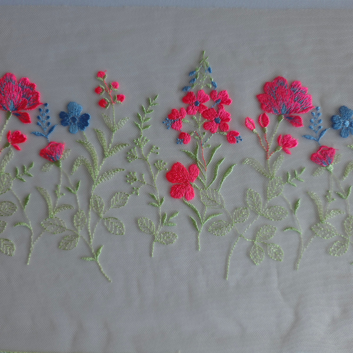 2026-112 peach kleurig tule kant voorzien van veldbloemen in lichtgroen, neon roze en korenbloem blauw